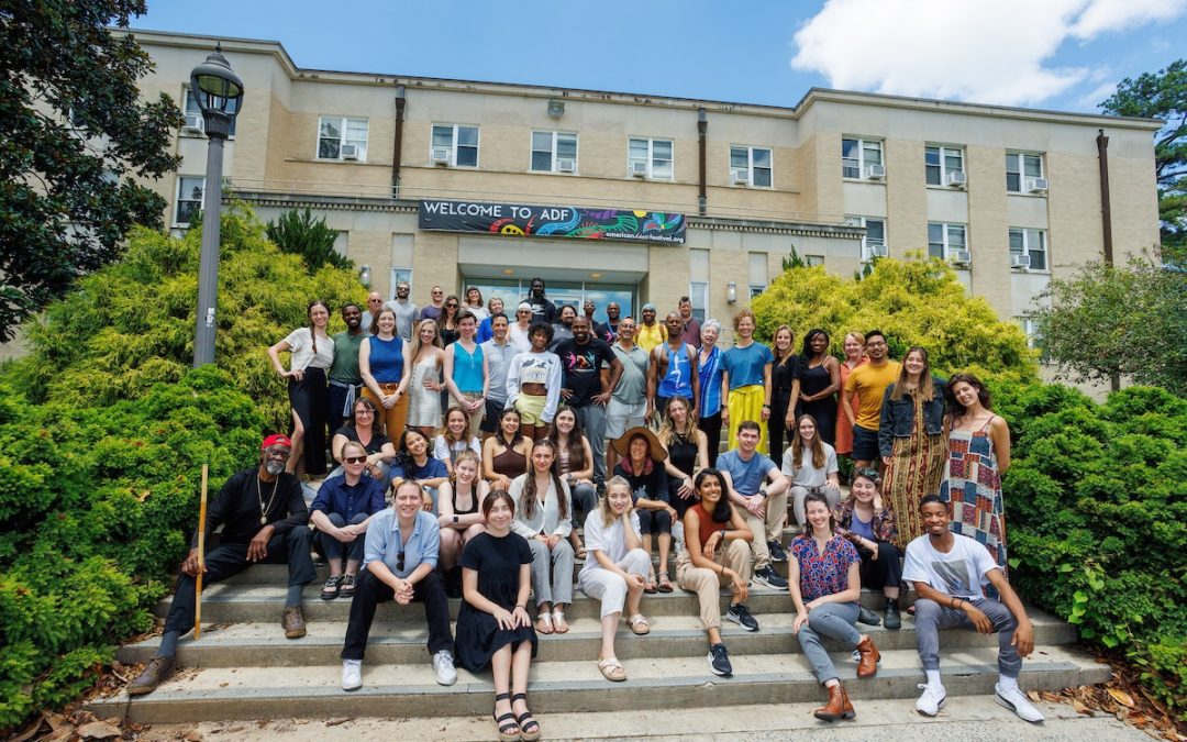 ADF summer staff sitting and standing on stairs. Building in background has a banner stating Welcome to ADF