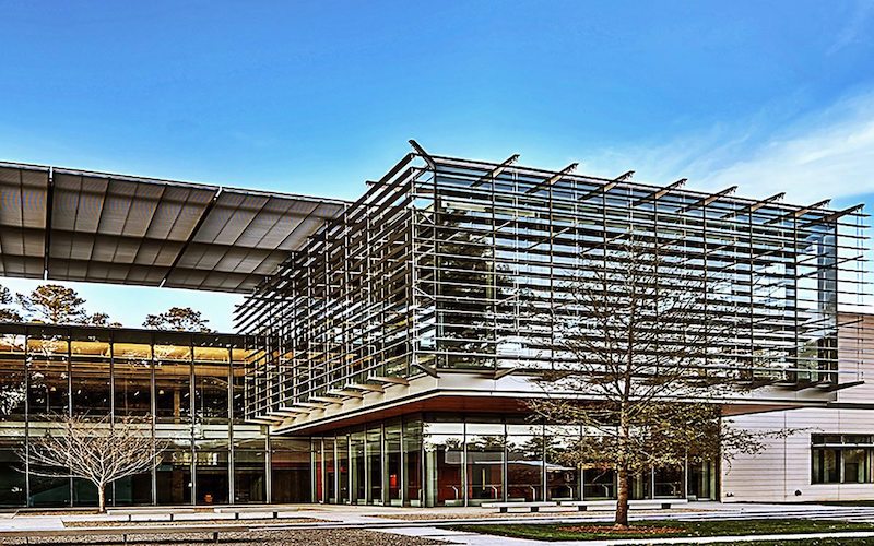 A two story building with large floor to ceiling windows