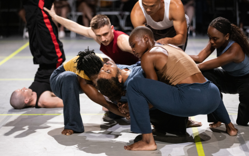 Multiple dancers partner together low to the floor.