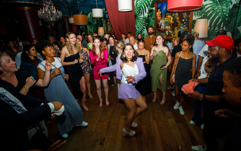 A woman dances in the center of a circle of people.