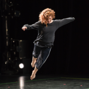 Jenna Riegel leaping in the air on stage